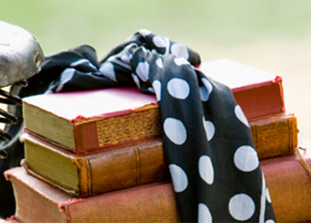 Books wrapped with a bow on the back of bicycle.