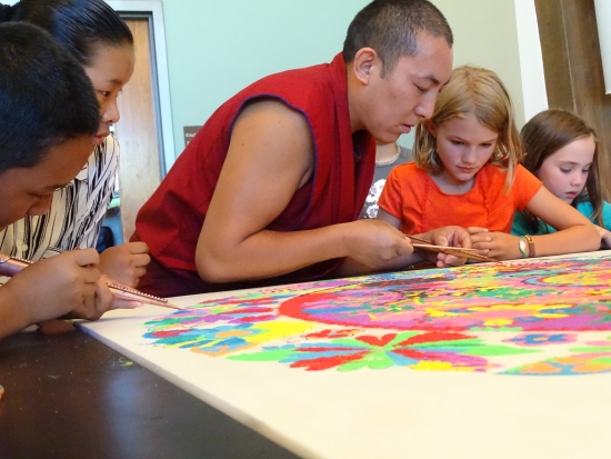 Even the monks joined the play at the Community Sand Painting table -- and offered a few hot sand painting tips and some revered mentoring.